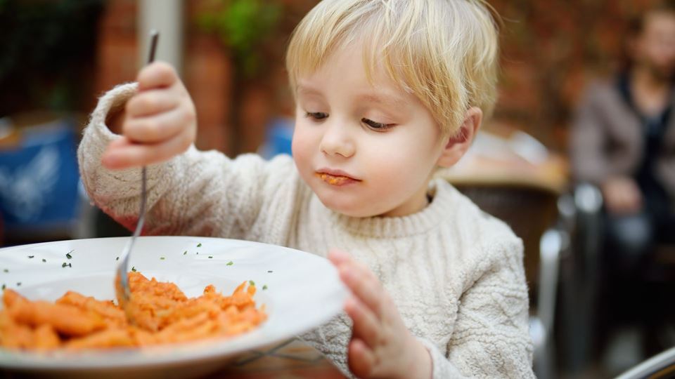 Criança a comer sozinha em restaurante - Destaque